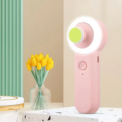 Gros plan sur le Coupe Ongles Électrique Sécurisé à LED La LumiOngles™ rose, avec sa lumière annulaire allumée, posé sur un support décoratif