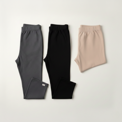 Pack Trio Besoin Bébé : ensemble de maternité comprenant deux leggings longs thermiques gris et noir et un short de soutien beige.