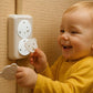 Enfant souriant avec plusieurs protèges-prises bébé ourson™